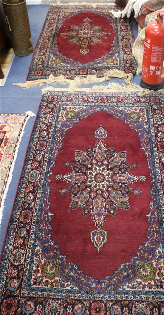 A pair of Kashan red ground rugs, 5ft 4in by 3ft 3in.